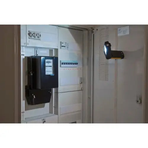 Verkstedslampe LED, festet på innsiden av et åpent sikringsskap og lyser opp det elektriske panelet.