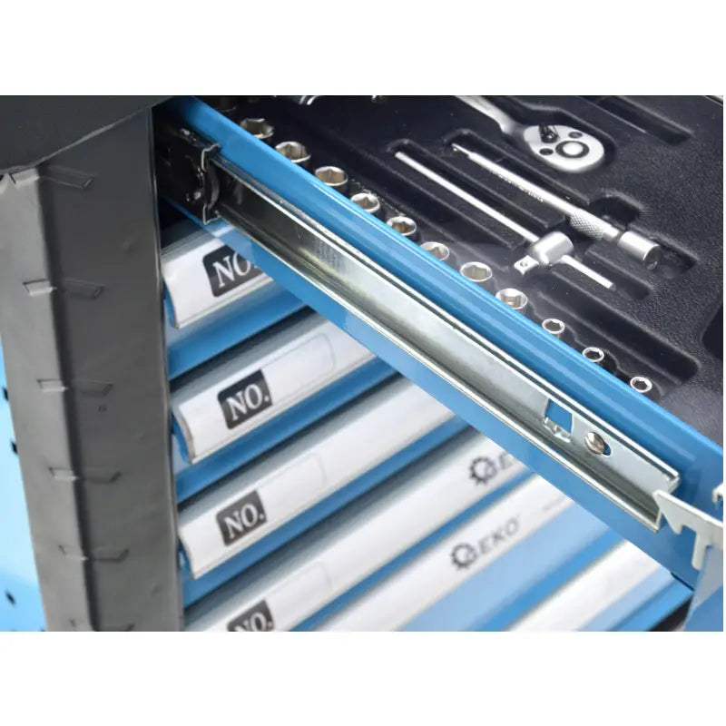 Blå verkstedsvogn, nærbilde av åpen skuff med sort innlegg, sorterte metallverktøy og synlig glideskinne.