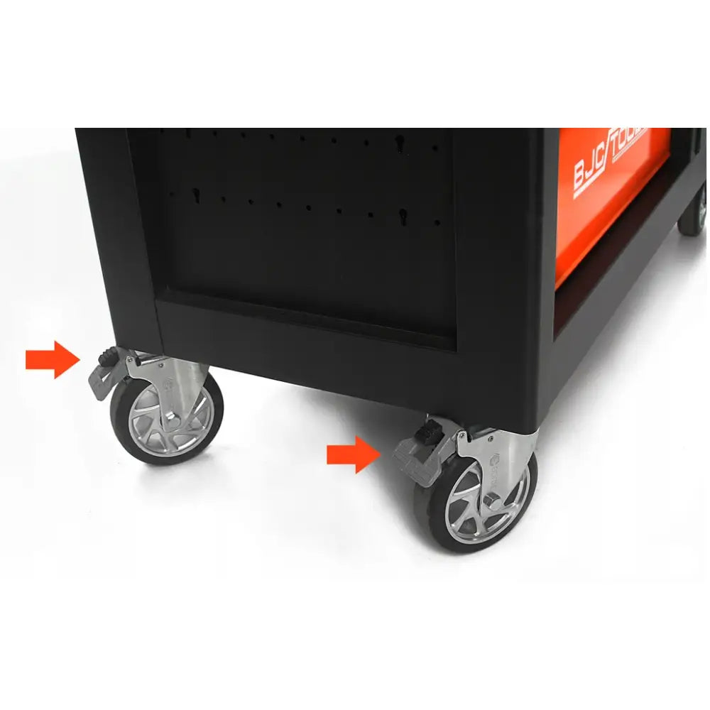 Verkstedsvogn, nærbilde av to sølvfargede hjul med bremser markert med røde piler mot sort skap.