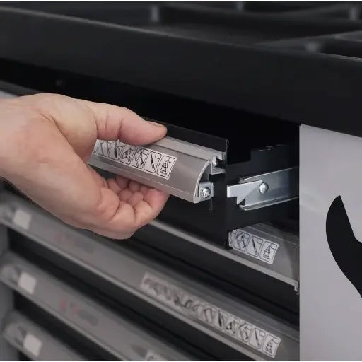 Verkstedvogn Tagred, nærbilde av metallskuff som trekkes ut, synlige etiketter og illustrasjoner på skuffen.