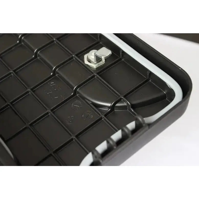 Verktøykasse Daken Blackit 550, nærbilde av sort plastdeksel med rutenett, grå tetning og hjørnelås.