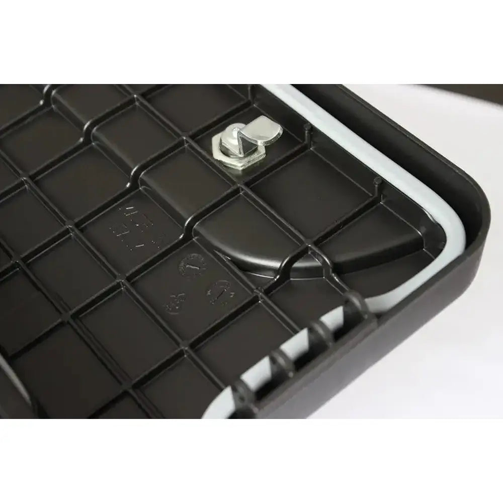 Verktøykasse Daken Blackit, nærbilde av hjørne med rutemønstret plast, grå tetningslist og metallbeslag.