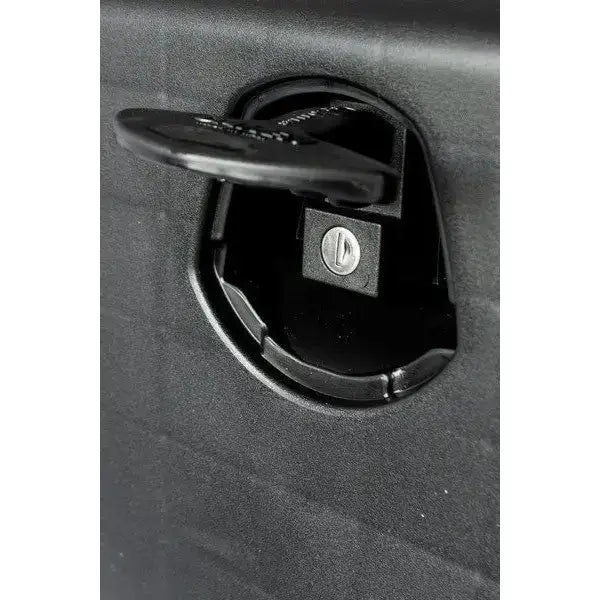 Verktøykasse Daken Just 500, nærbilde av sort plastlås med metallskrue og åpent lokk mot matt svart bakgrunn.