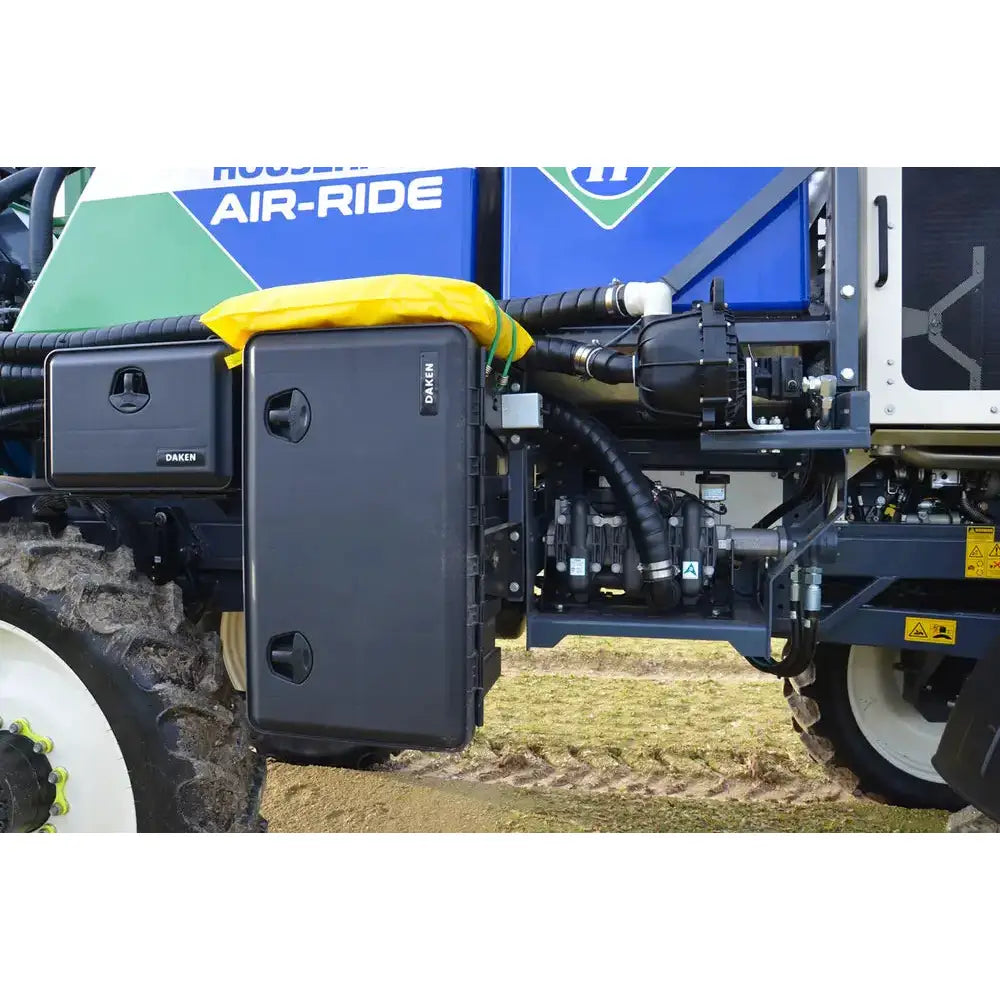 Verktøykasse Daken Just 750, svart plastboks med to håndtak og gul presenning, montert på maskinside.