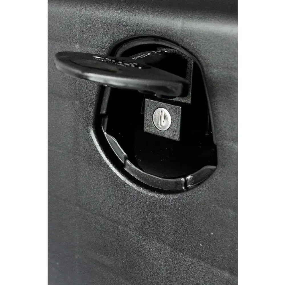 Verktøykasse Just 750, nærbilde av svart plastlås med nøkkelhull, delvis åpen fra skrå vinkel.