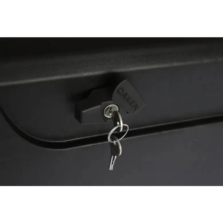 Verktøykasse med håndtak, nærbilde av svart DAKEN-lås med nøkkel mot matt svart overflate.