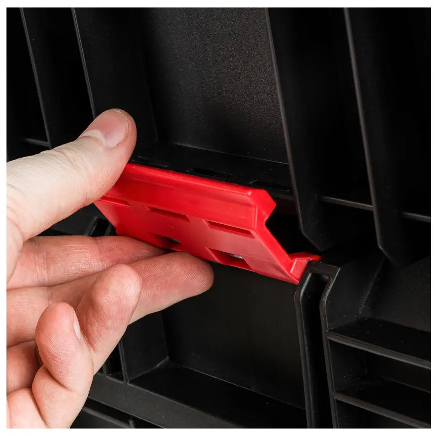 Verktøykasse på hjul Kistenberg, nærbilde av rød plastlås som løftes for å åpne låsemekanismen.