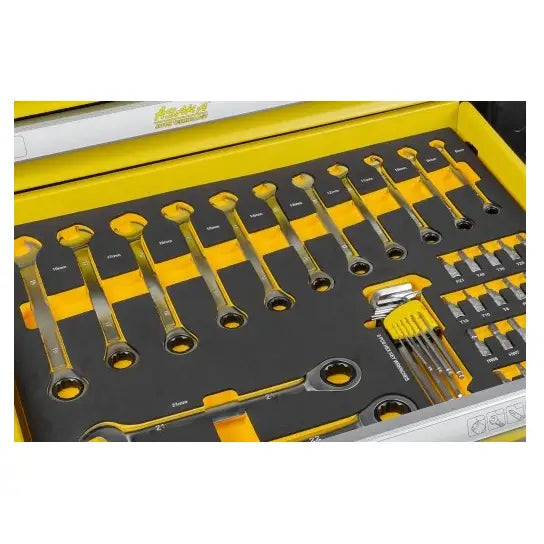 Verktøysett med 156 deler organisert i sort og gult skuminnlegg, sett ovenfra i en skuffeseksjon.