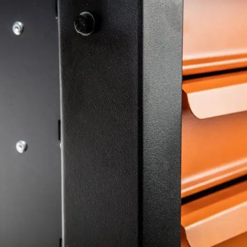 Verktøyskap med syv oransje skuffer, nærbilde som viser håndtak, skruer og metallstruktur i detalj.