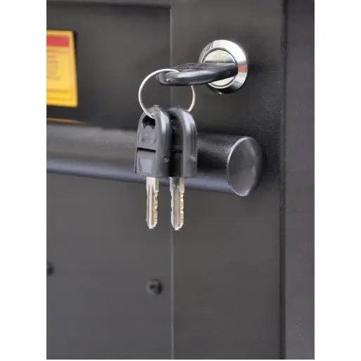 Verktøyskap Richmann, nærbilde av to nøkler i sølvfarget lås på matt svart dør, sett fra siden.