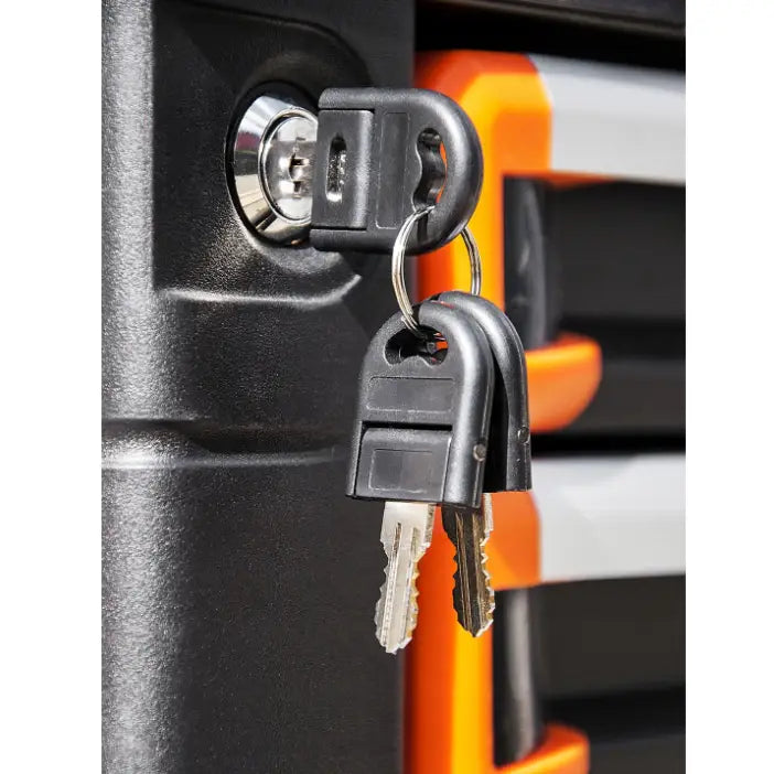 Verktøyvogn Corona, nærbilde av to nøkler i sylinderlås på sort skap med oransje og grå detaljer bak.