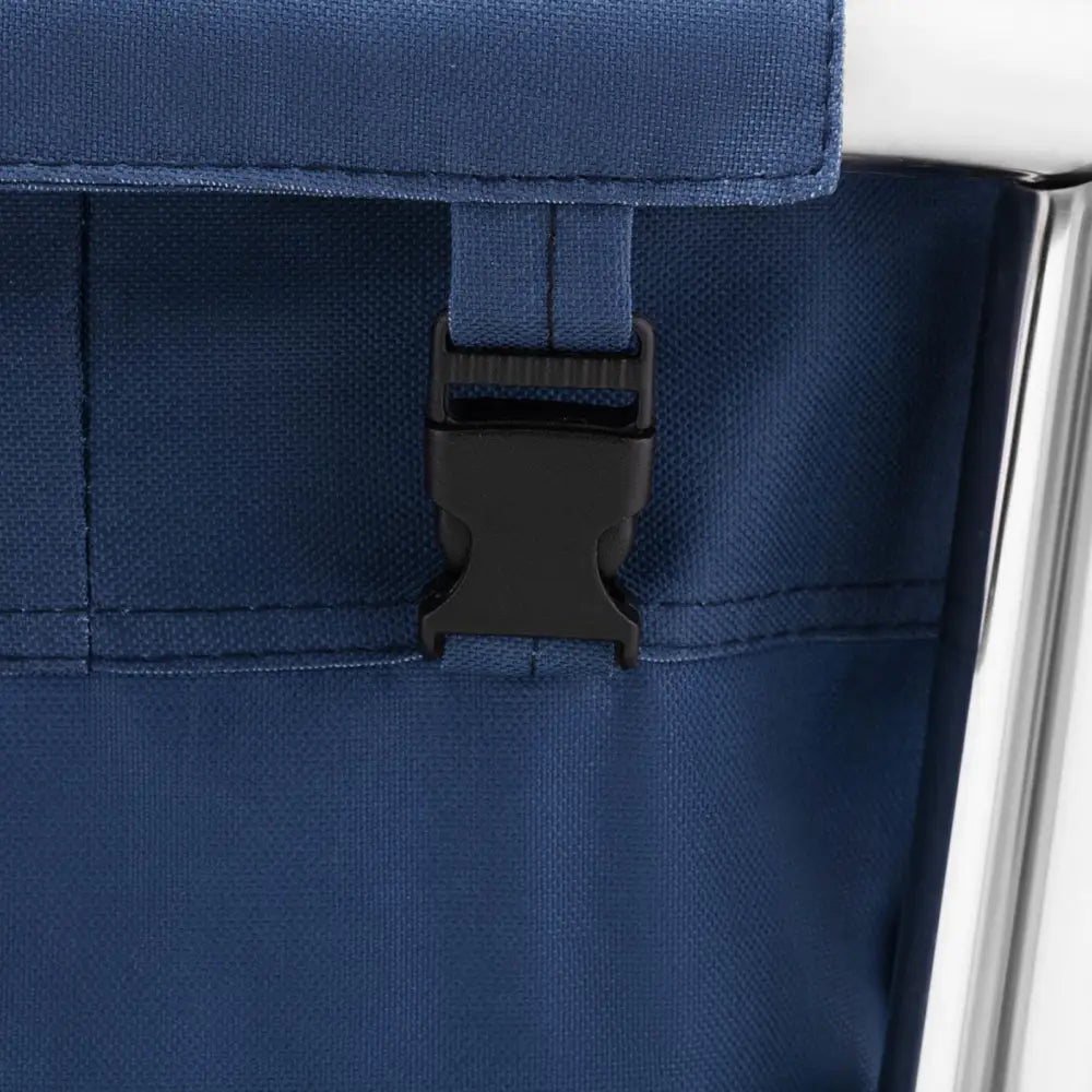 Svart plastspenne på blått tekstil, detaljvisning av sømmer og sølvfarget aluminiumsramme på vogn.