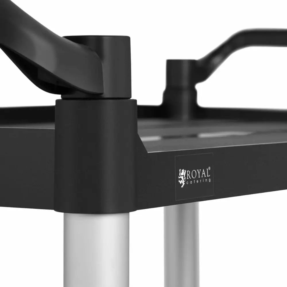 Vognservitørplattform, nærbilde av svart hjørne med sølvben og synlig Royal Catering-logo.