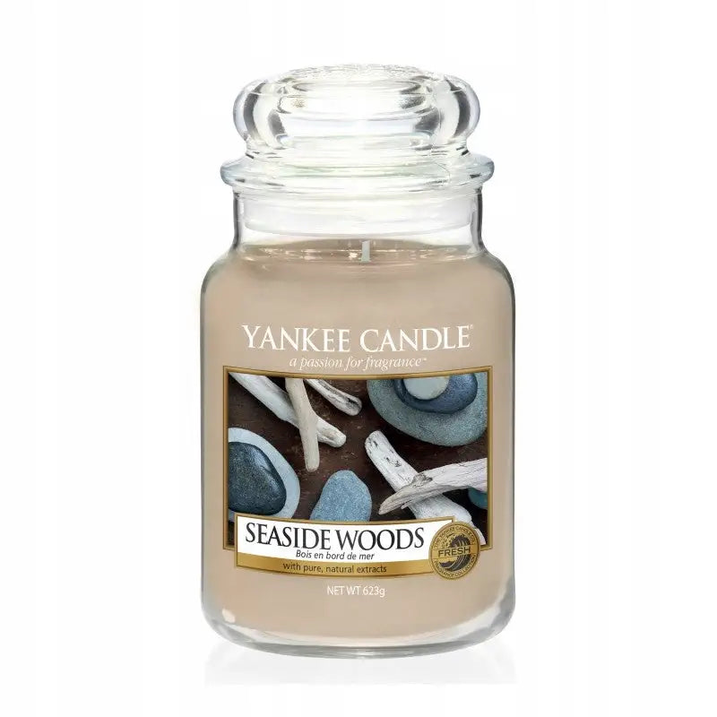 Yankee Candle duftlys Seaside Wood, stort beige vokslys i glasskrukke med lokk og motiv av steiner og drivved.