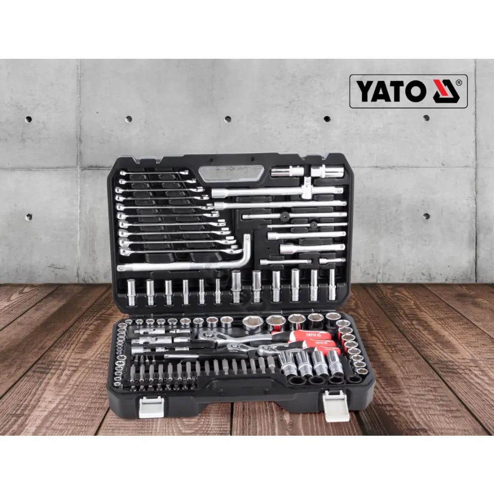 Yato Verktøysett XXL, åpen sort plastkoffert med 128 deler, pipenøkler og skralle, sett rett forfra på tregulv.