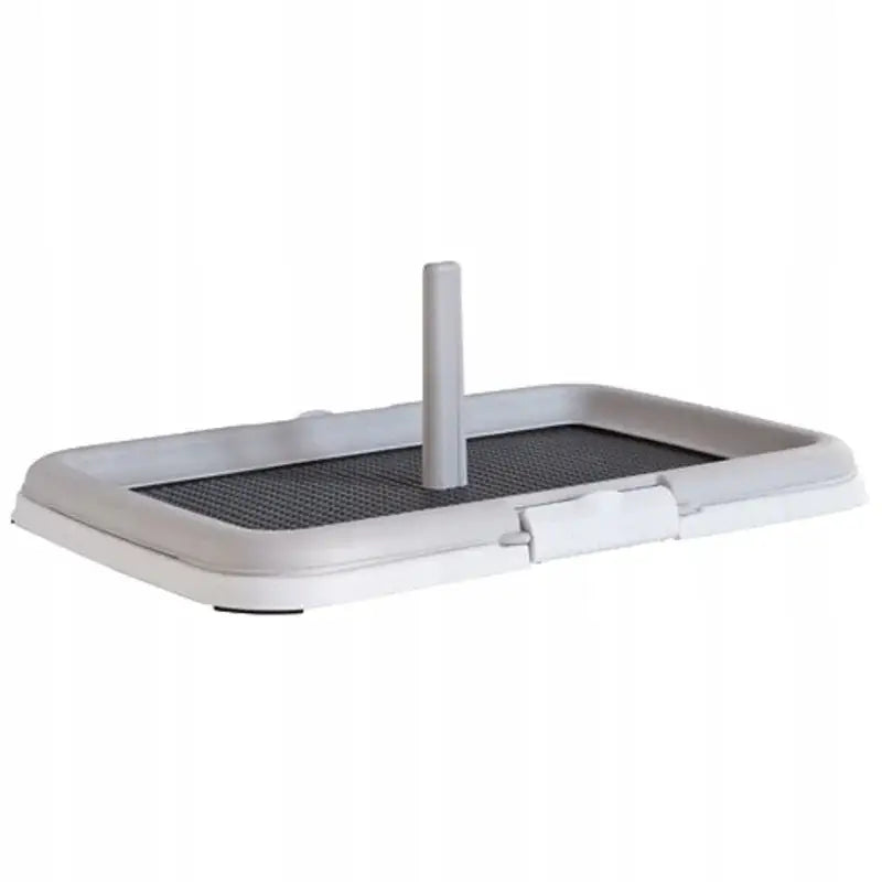 Zolux Puppy Trainer hundetoalett, lysegrått plastbrett med mørkt nett og vertikal pinne sett skrått forfra.