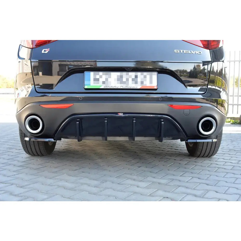 Alfa Romeo Stelvio 16- - Deler Og Tilbehør, svart bakparti med doble eksosrør, røde refleksdetaljer og Alfa Romeo-emblem.