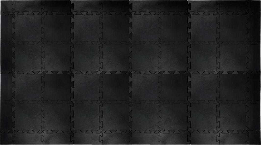 Gummigulv med sammenkoblede, svarte treningsmatter i puslespillmønster, sett ovenfra på matt overflate.