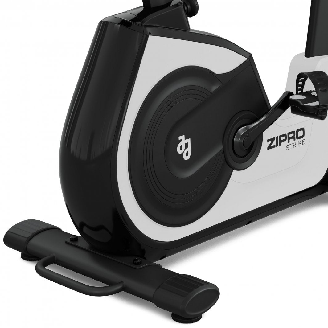 Trimsykkel med sorte og hvite pedaler og svinghjul, sett fra siden. Synlig bærehåndtak nederst.