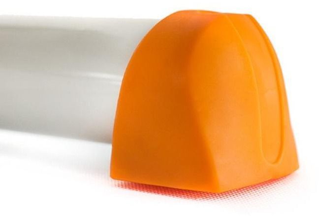 Stepmaskin med hvit sylinderform og oransje plastlokk, nærbilde fra siden med fokus på avrundet endestykke.