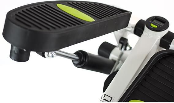 Stepper med sort og grønn strukturert fotpedal, synlig metallramme, demper og LCD-skjerm sett fra siden.