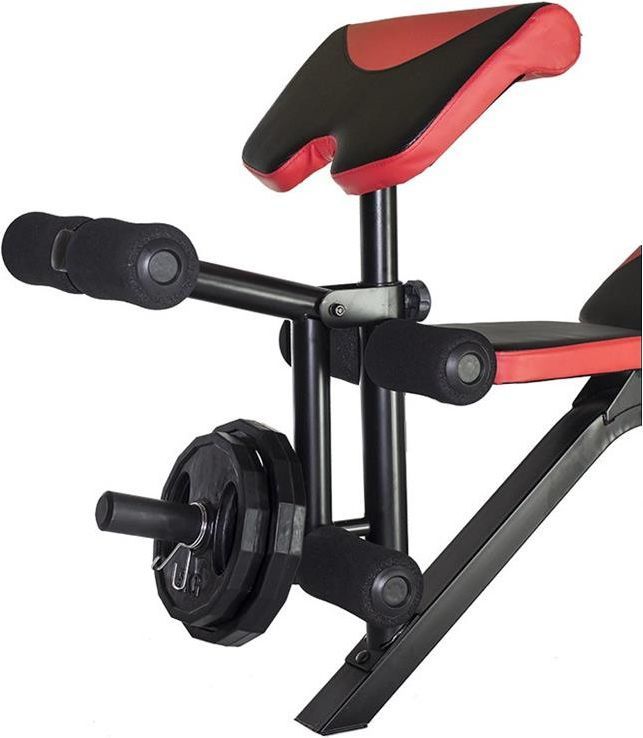 Benkpress med sorte og røde puter, skumgummistoppere og vektstang med vektskiver, sett fra siden.