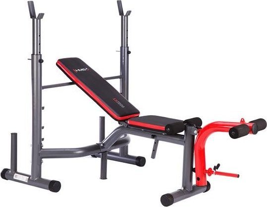 Multifunksjonell Treningsbenk i sort og rødt med polstret sete, ryggstøtte, armcurl-pads og beinapparat sett forfra.