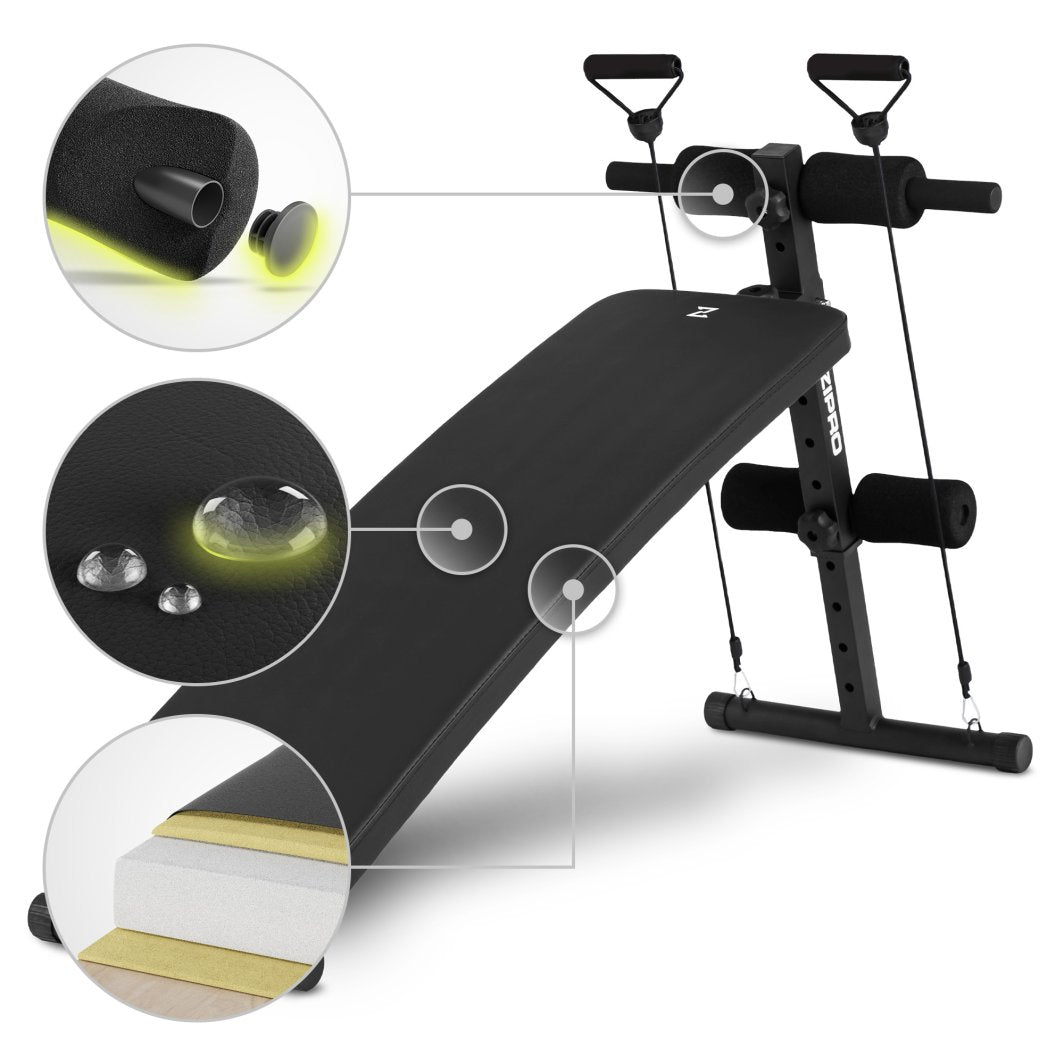 Treningsbenk i sort med polstrede skumruller, treningsstrikker og vannavstøtende trekk sett fra skrå vinkel.