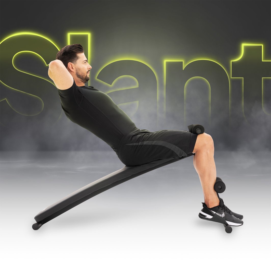 Treningsbenk Justerbar i svart brukes av mann som gjør sit-ups, sett fra siden med polstrede benholdere.