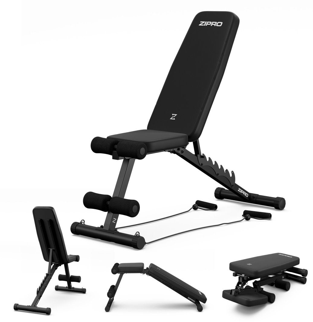 Treningsbenk i svart metall med polstring, skumputer til bena og festede treningsstrikker, vises sammenslått.