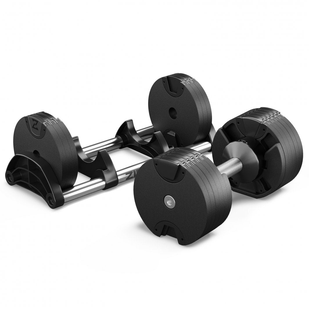 Hantel i sort og sølv med runde vektskiver, delvis plassert i stativ, sett fra skrått perspektiv.