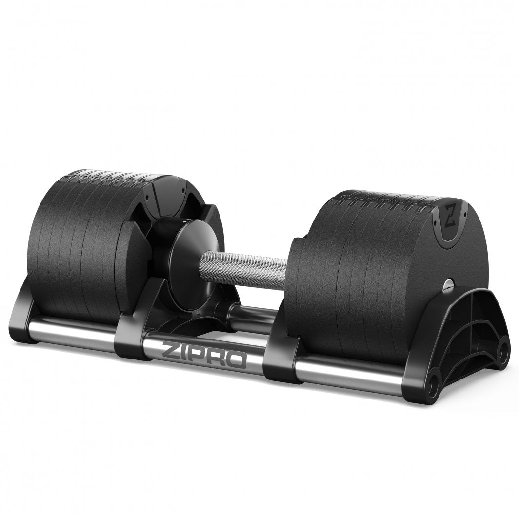 Justerbar Manual med sort håndtak og vektplater, ligger på et lyst underlag, klar til hjemmetrening.