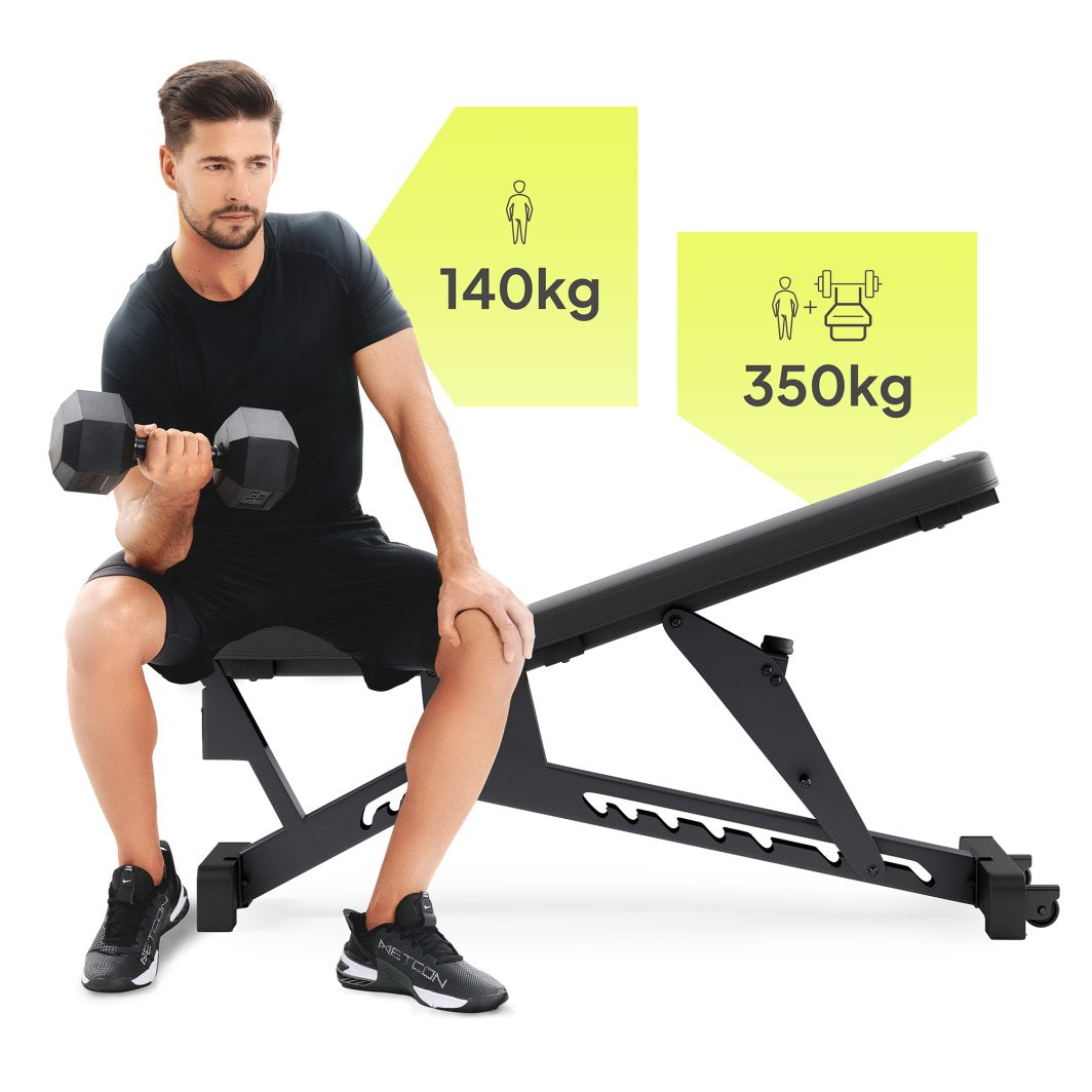 Multifunksjonell Treningsbenk i svart metall med polstret sete, person løfter manual, maksvekt 140 kg vises.