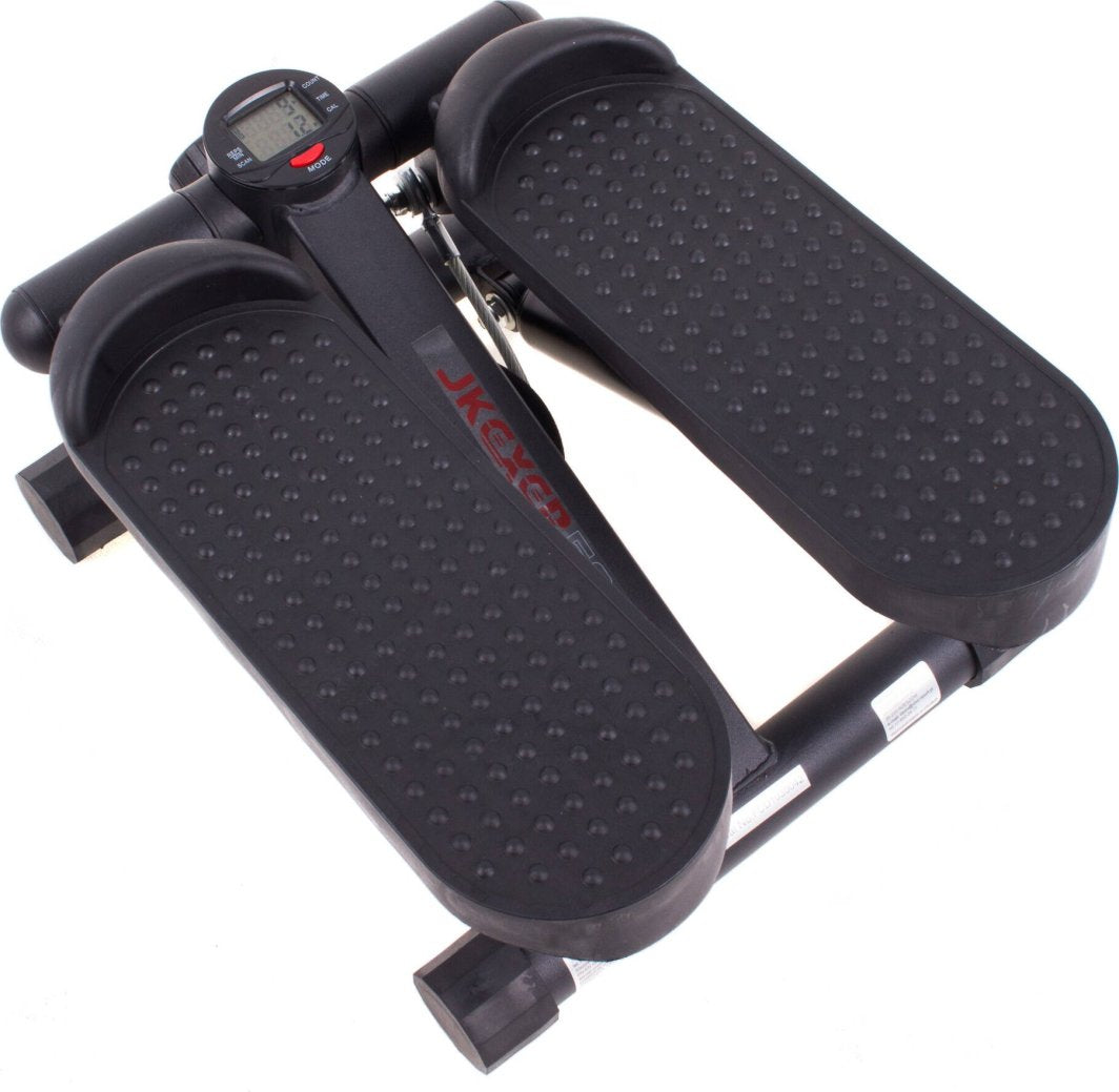 Stepper Trening kompakt stepmaskin i sort plast og metall med brede fotplater og digital skjerm mellom plattformene.