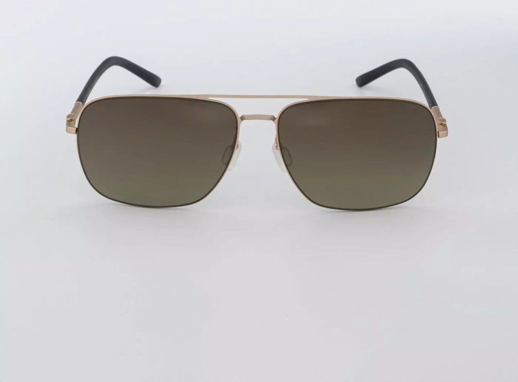 Solbrille med firkantede, brune glass, tynn gullfarget metallramme og sorte stenger, sett rett forfra.