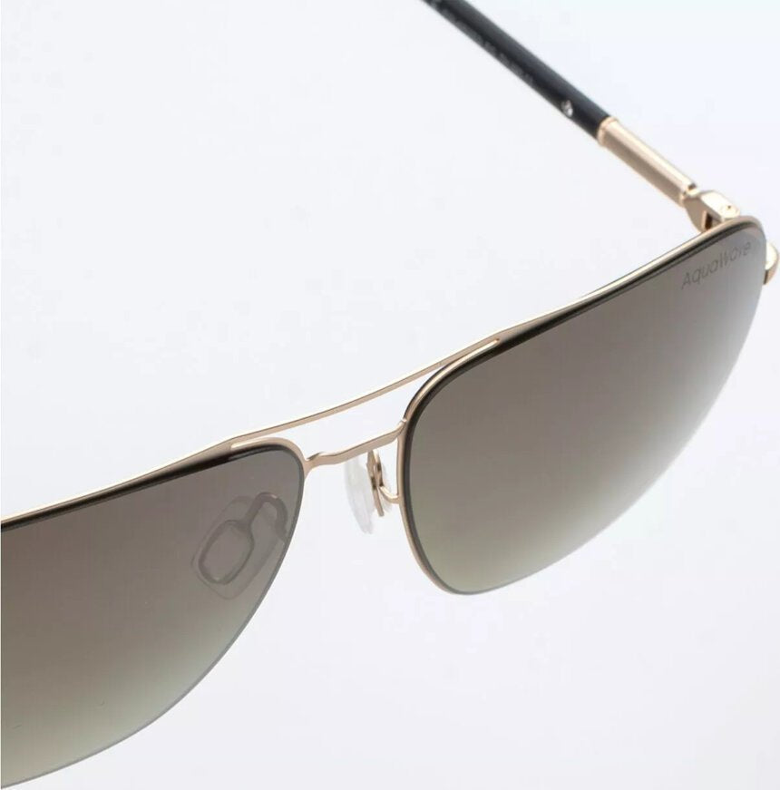 Sportsbriller med gullfargede metallrammer og gråtonede glass, fokus på bro og nesestøtte fra siden.