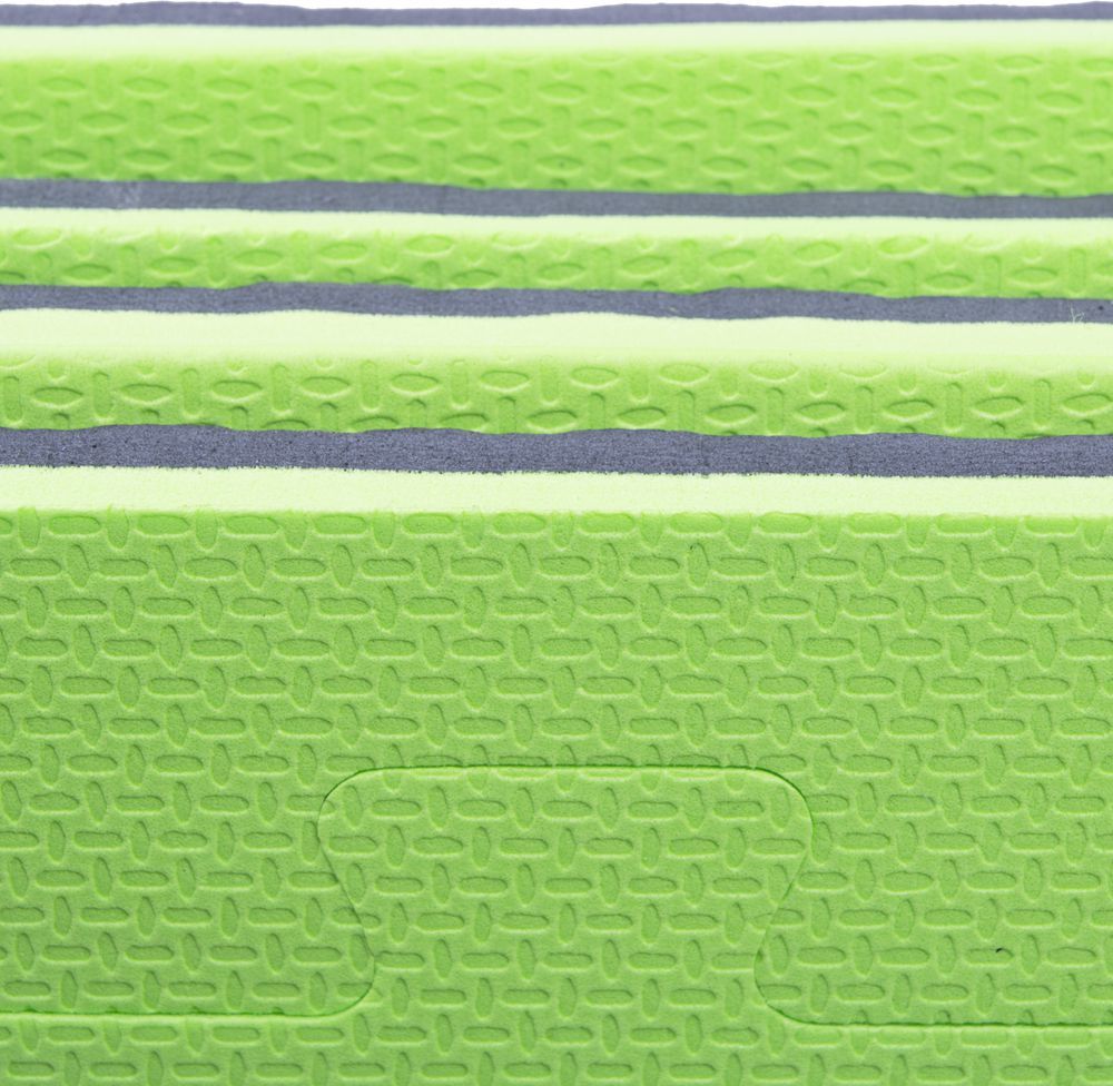 Puslematte i grønt og grått EVA-skum med mønstret overflate og tydelige skjøter, sett fra siden.