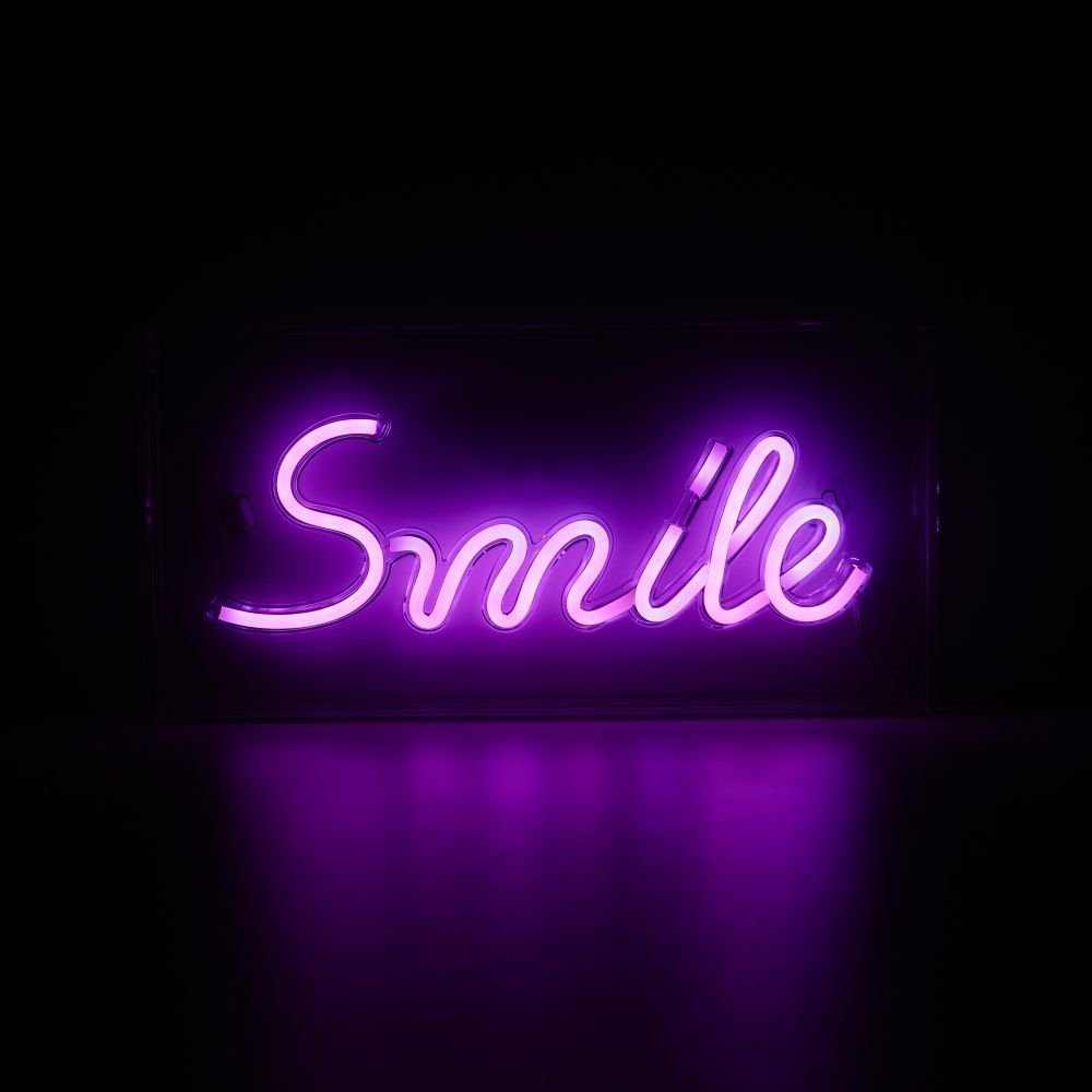 Løpebånd neonskilt SMILE 15cm rosa LED sett forfra med håndskrevet tekst mot mørk bakgrunn.