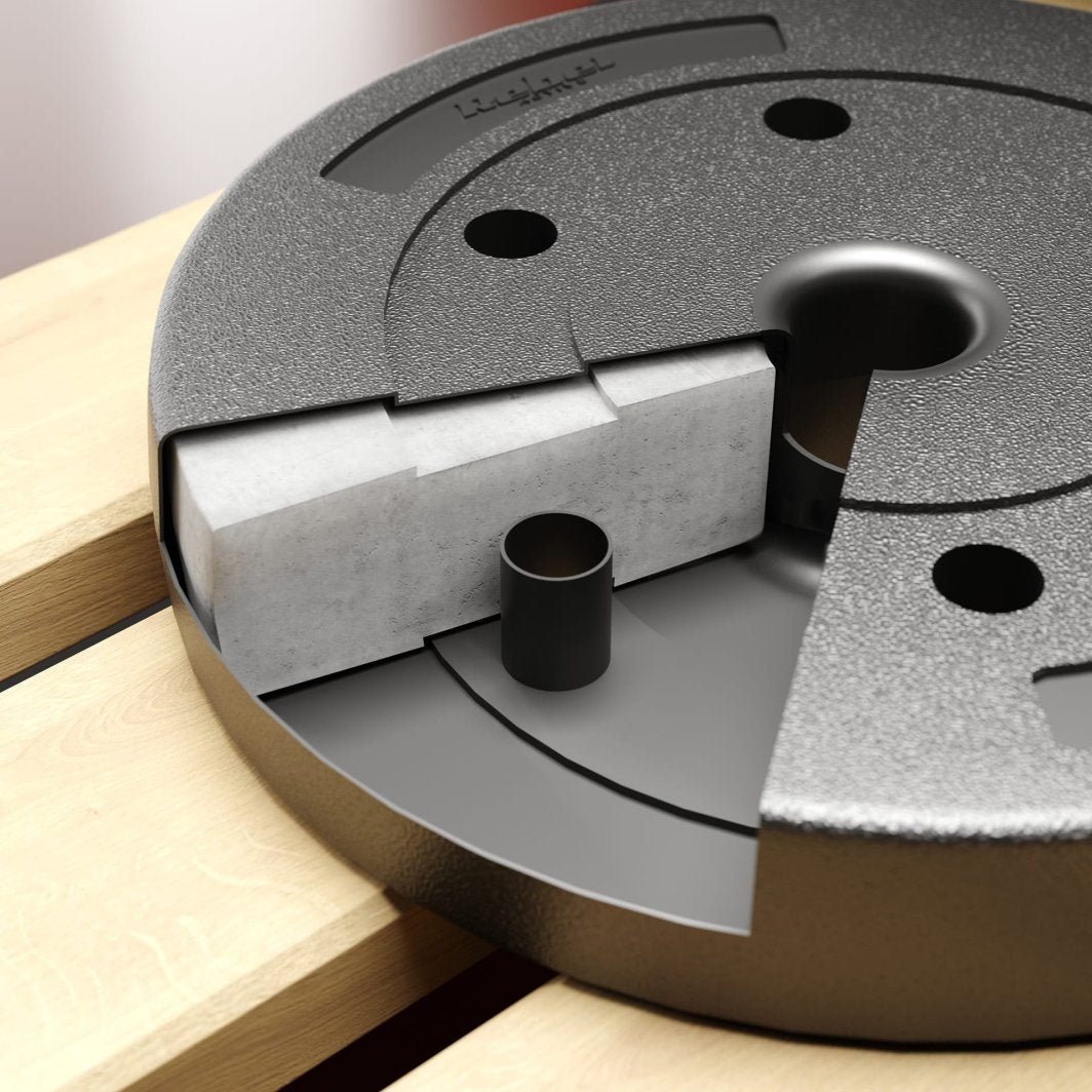 Vektskiver 50mm, to sorte skiver med grov overflate og lysgrått element, ligger på lyst treverk.