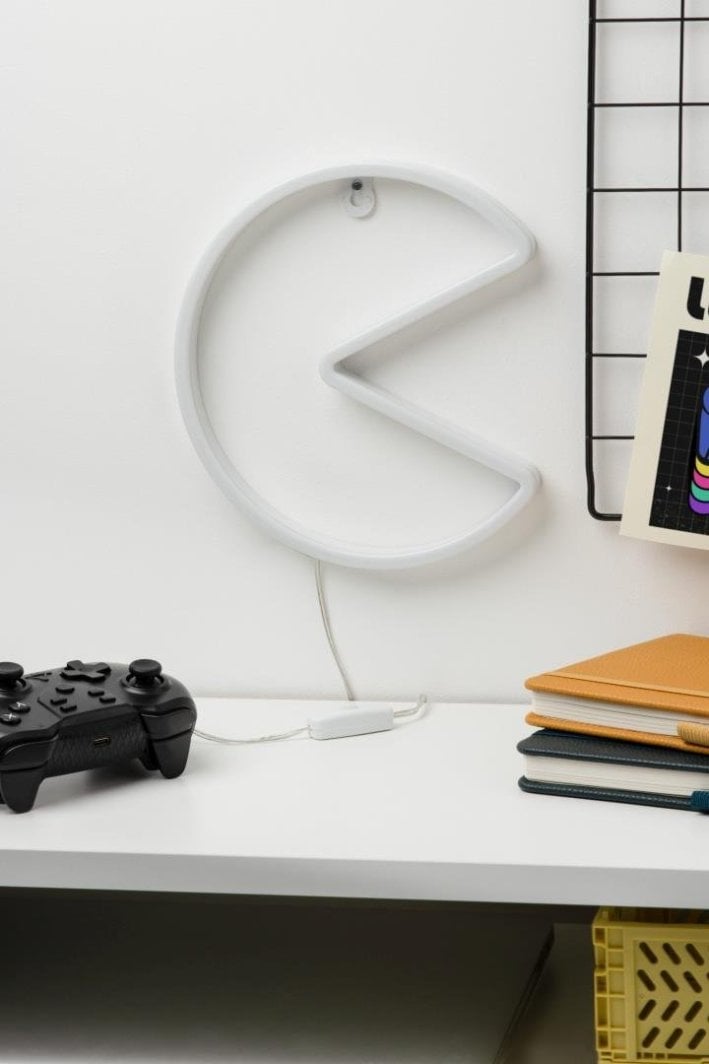 Tredemølle hjemme vegglampe Pac-Man i hvitt, sidevisning med ledning over skrivebord og kontorrekvisita.