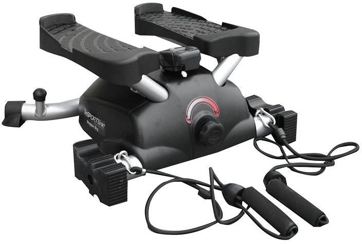 Stepmaskin med sort og sølv design, to teksturerte pedaler og treningsstrikker med håndtak foran, sett skrått forfra.