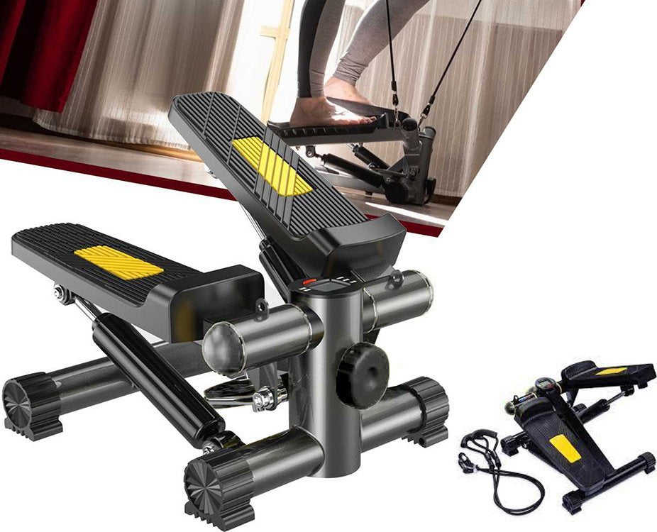 Stepmaskin i sort metall med gule detaljer, to tredematter og treningsstrikk, sett fra skrå vinkel.