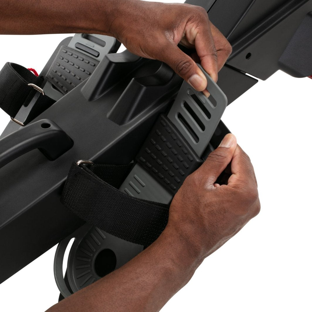 Romaskin med justerbar sort og grå pedal, teksturert overflate og stropp, hånd tilpasser innstillingen.