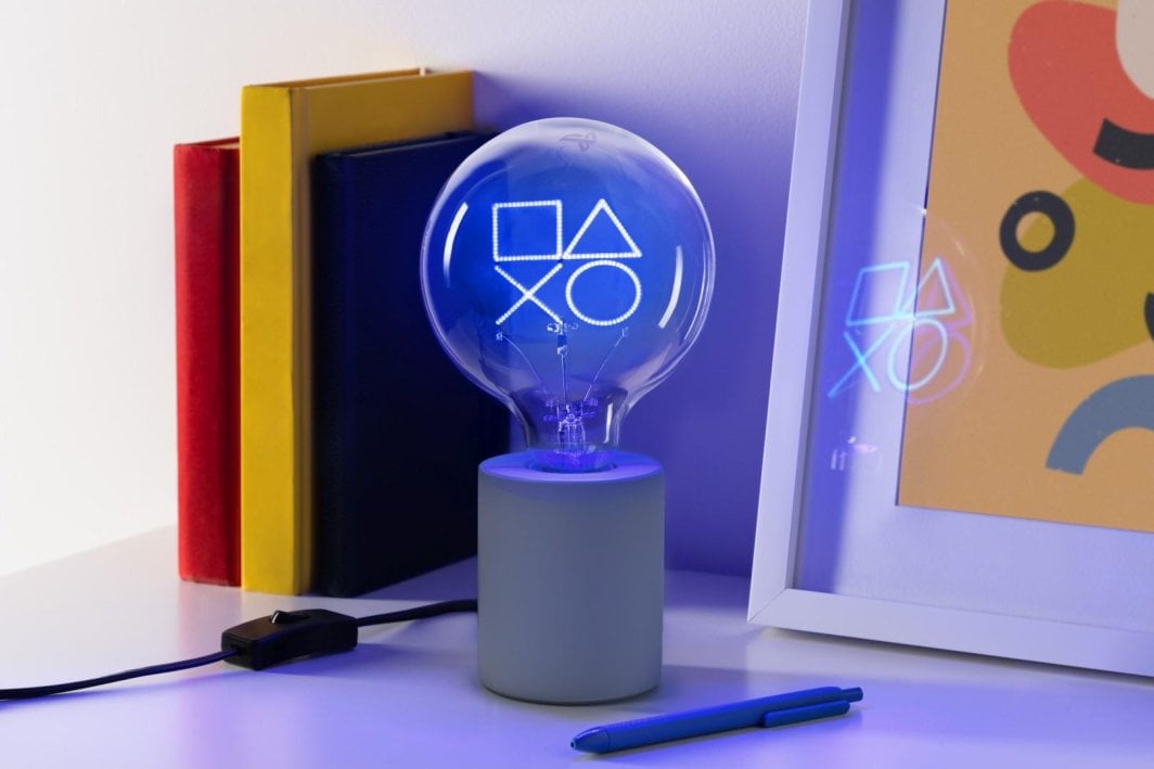 Tredemølle hjemme LED-neonlampe med blå PlayStation-symboler på grå base, sett på skrivebord.