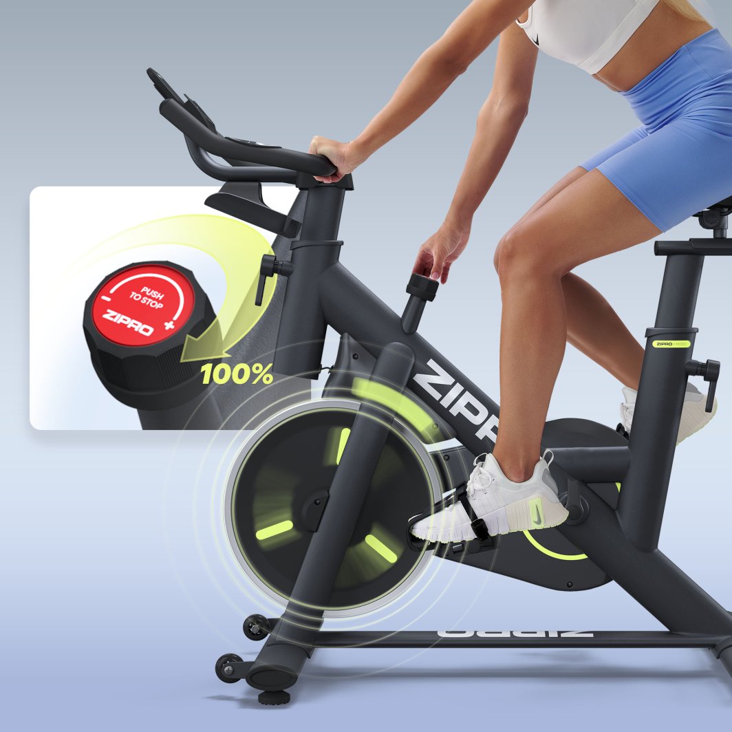 Trimsykkel med sorte og grønne detaljer brukt av person, nærbilde av rød justeringsknapp og pedal i bevegelse.