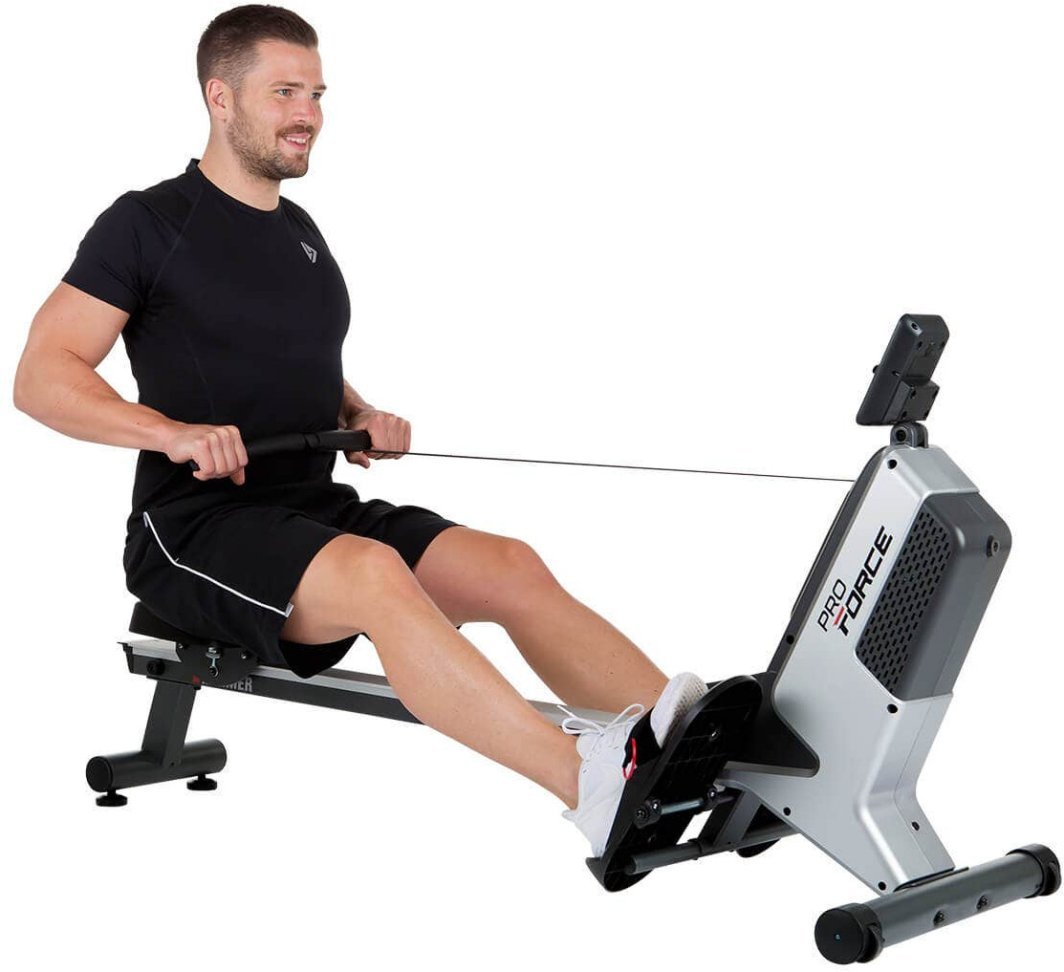 Romaskin i sølv og sort brukes av mann, sett fra siden med tydelig sitteplate, fotstøtter og håndtak.