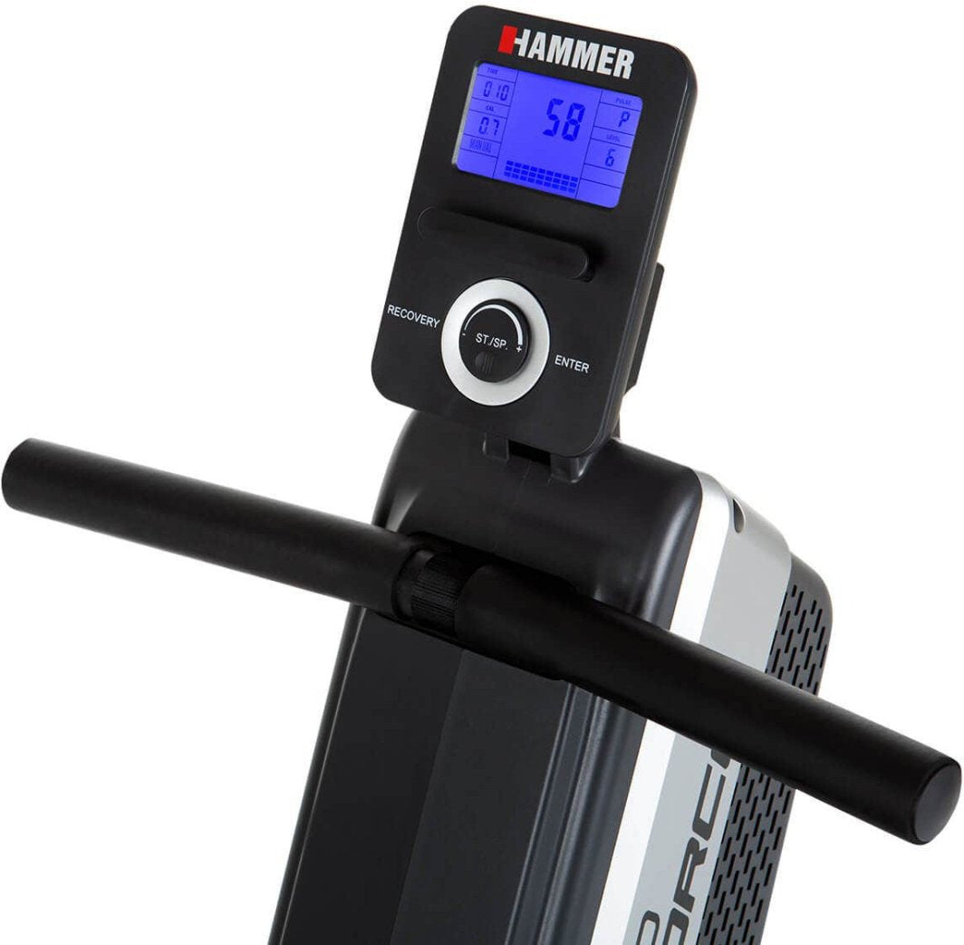 Treningsmaskin med digitalt display, blå bakgrunnsbelysning, svarte håndtak og sølvfarget apparathus, sett skrått.