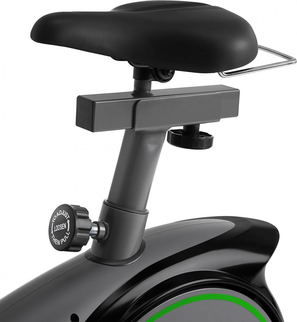 Treningssykkel med sort sete og justerbar metallstang, synlig justeringsskrue og grønt felt på rammen.