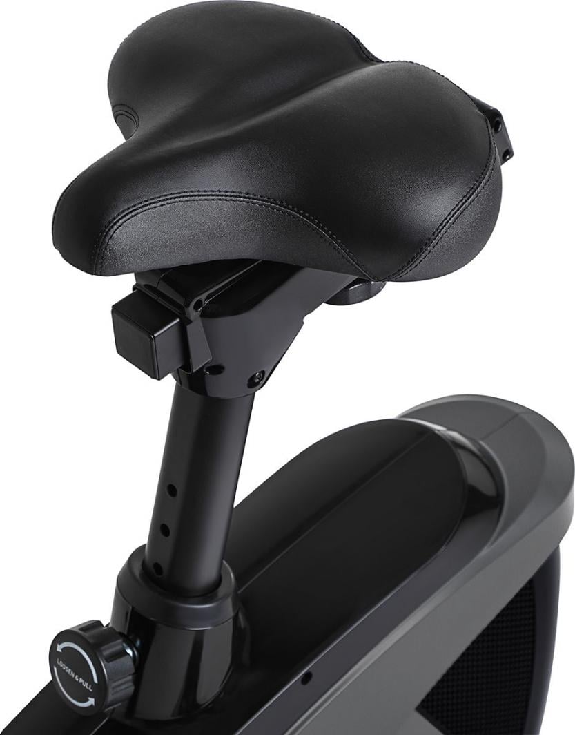 Trimsykkel med sort, polstret sete i kunstskinn, sett fra siden og ovenfra, justerbar setepinne og låsemekanisme.