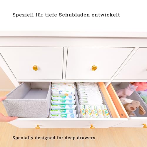 Skuffeinnsats i grått organisert i hvit kommode med bleier, våtservietter og leker, sett ovenfra.